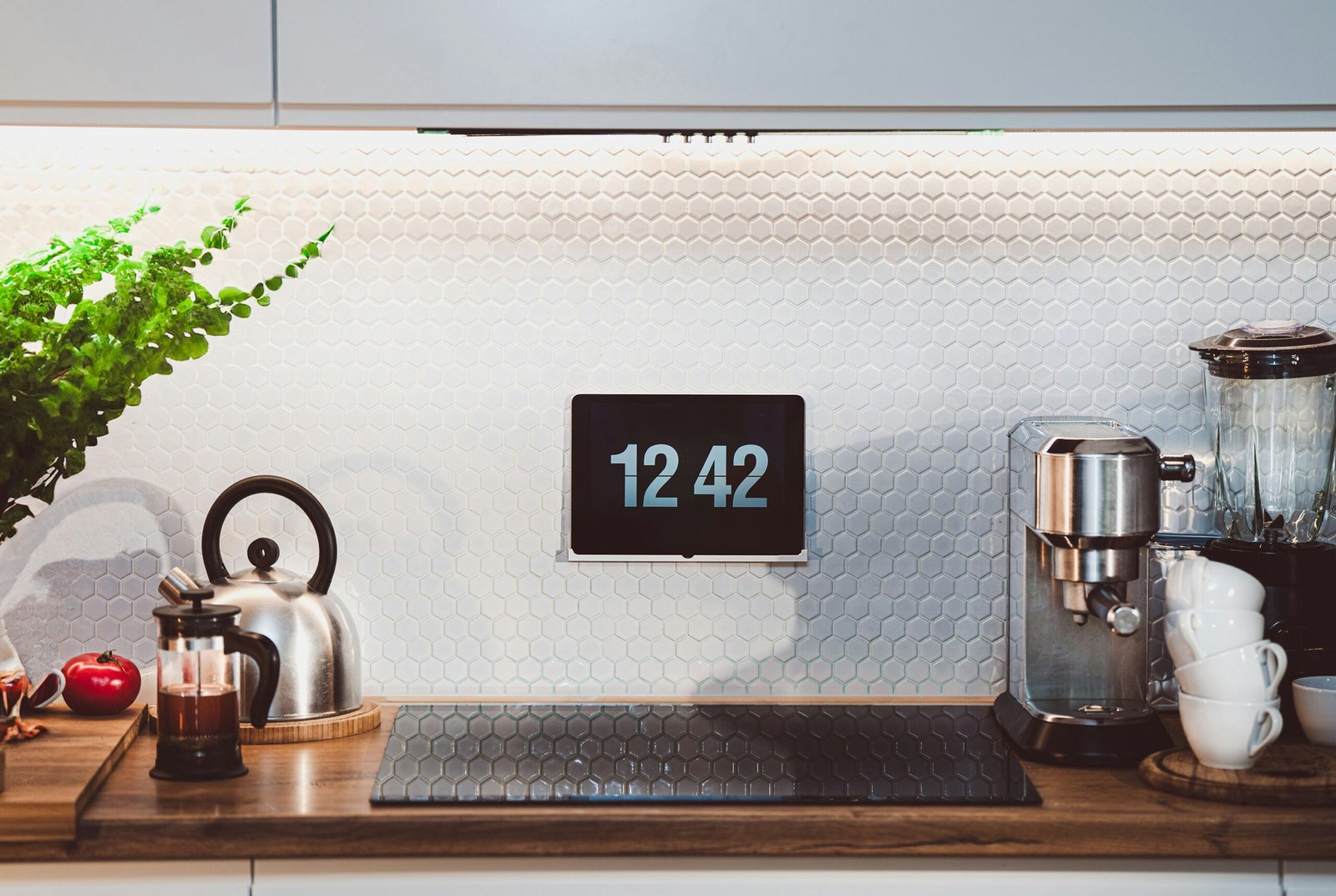 a kitchen counter with a clock and a potted plant